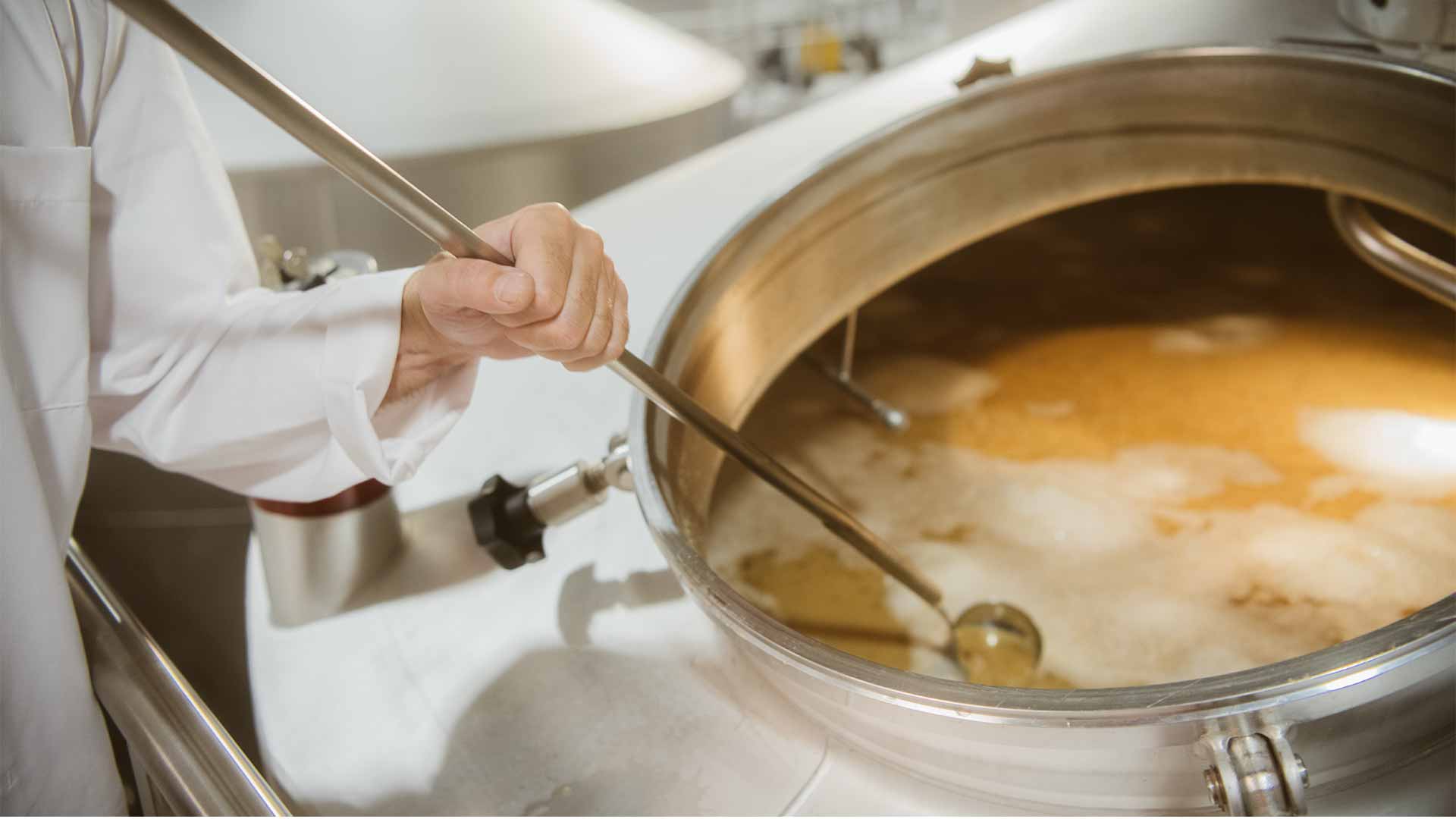 Ein Holsten Mitarbeiter rührt in der Maische